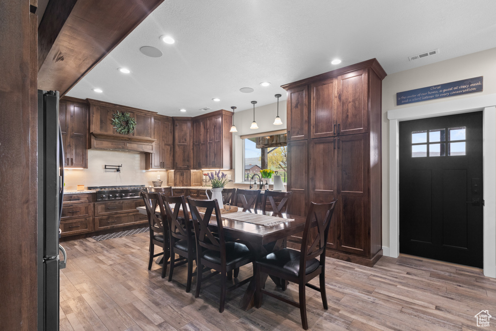Dining space with light wood-style flooring and recessed lighting