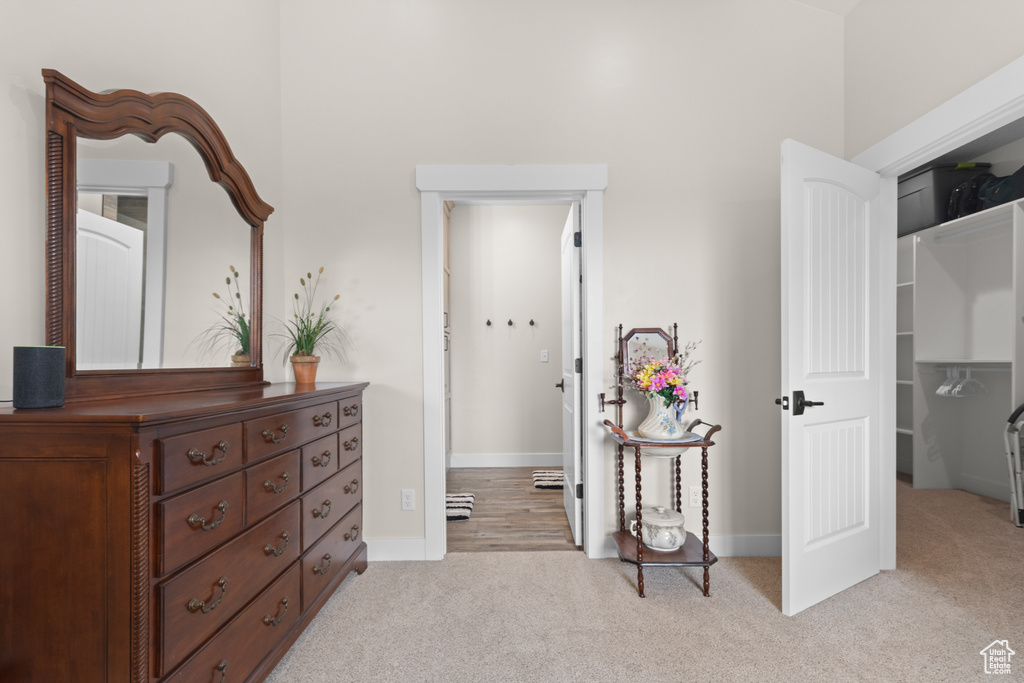 Hallway featuring light carpet and baseboards