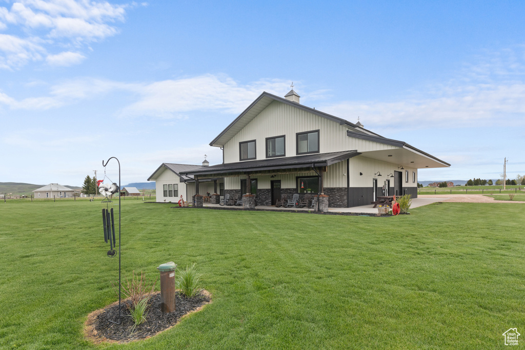 Back of property featuring a patio area, a chimney, and a yard