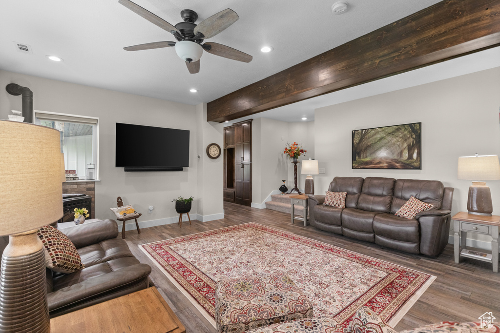 Living room featuring recessed lighting, wood finished floors, baseboards, ceiling fan, and beamed ceiling
