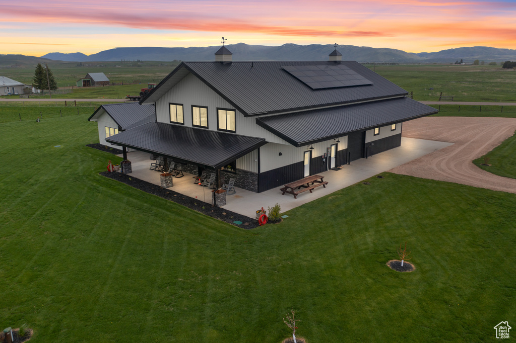 Rear view of property with a patio, a mountain view, solar panels, and metal roof