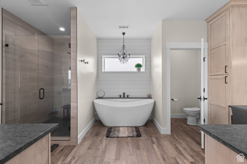 Full bath with a shower stall, vanity, toilet, baseboards, and a freestanding tub
