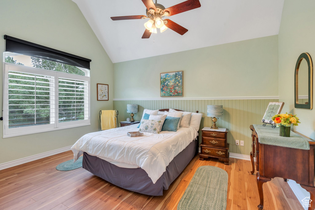 Bedroom featuring light wood-type flooring, ceiling fan, high vaulted ceiling, and baseboards