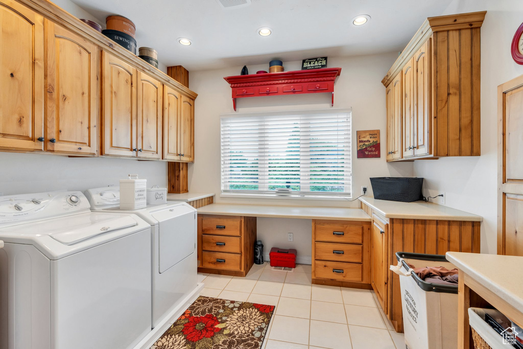 Laundry room with cabinet space, washing machine and dryer, a desk, light tile patterned floors, and recessed lighting