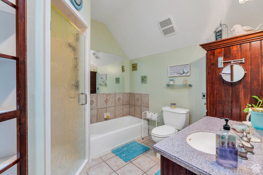 Full bath with lofted ceiling, a stall shower, tile patterned floors, a bath, and toilet