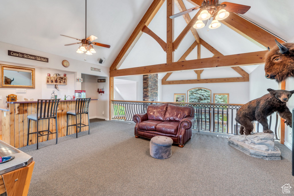 Carpeted living area with ceiling fan, high vaulted ceiling, beamed ceiling, and baseboards