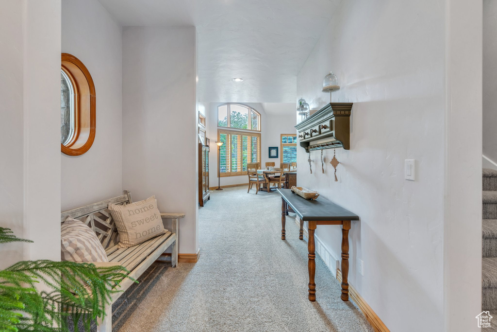 Corridor featuring carpet, stairs, and baseboards