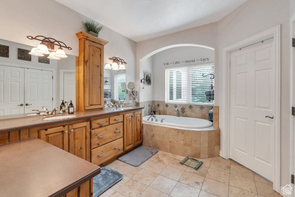 Full bath featuring a bath, double vanity, and tile patterned floors