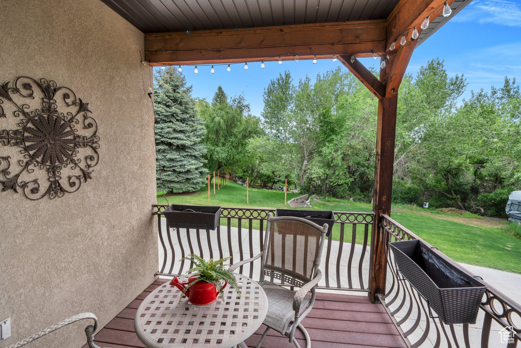 Wooden terrace with a lawn and view of scattered trees