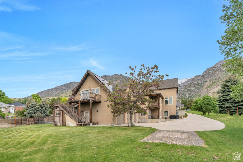 Rear view of house featuring stairs, stucco siding, and a deck with mountain view