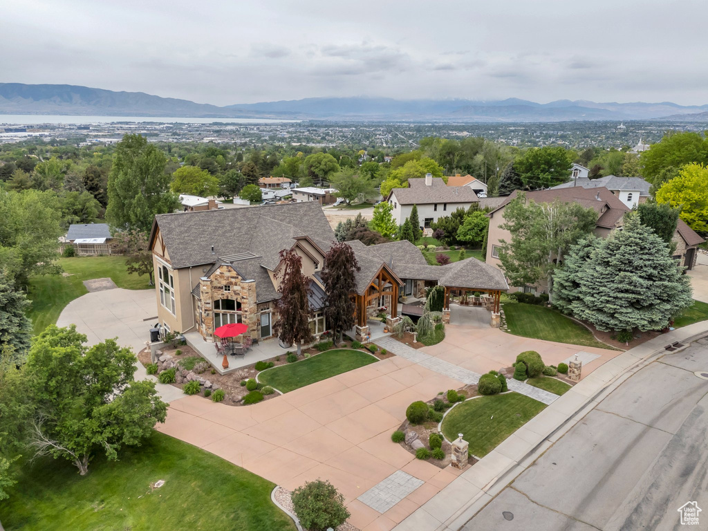 Aerial view of property and surrounding area featuring a mountain backdrop