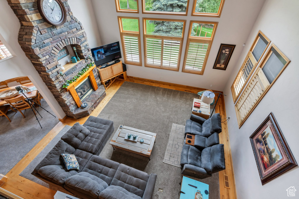 Living area featuring a high ceiling, a stone fireplace, and baseboards