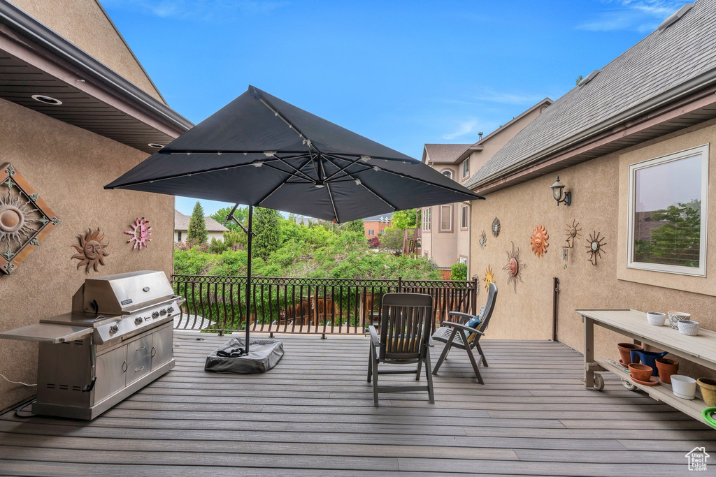 Wooden deck featuring a grill