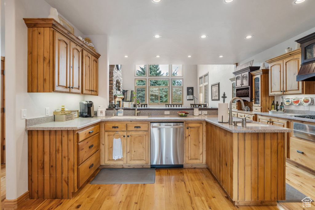 Kitchen with stainless steel appliances, a sink, recessed lighting, light wood finished floors, and a warming drawer