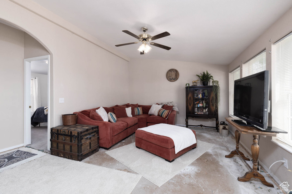 Living area featuring ceiling fan and arched walkways