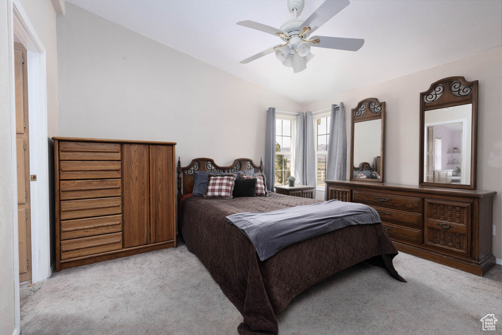 Carpeted bedroom with lofted ceiling and a ceiling fan