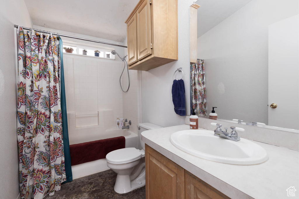 Full bath featuring toilet, vanity, and shower / bath combo with shower curtain