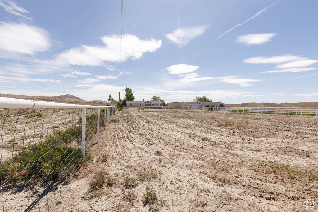 View of yard featuring fence, a view of rural / pastoral area, and a mountain view