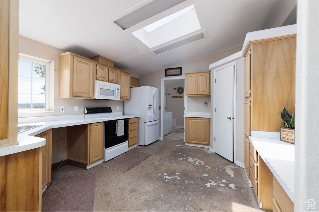 Kitchen featuring white appliances, vaulted ceiling, light brown cabinets, light countertops, and a skylight