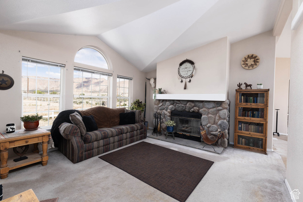 Carpeted living room featuring vaulted ceiling and a fireplace