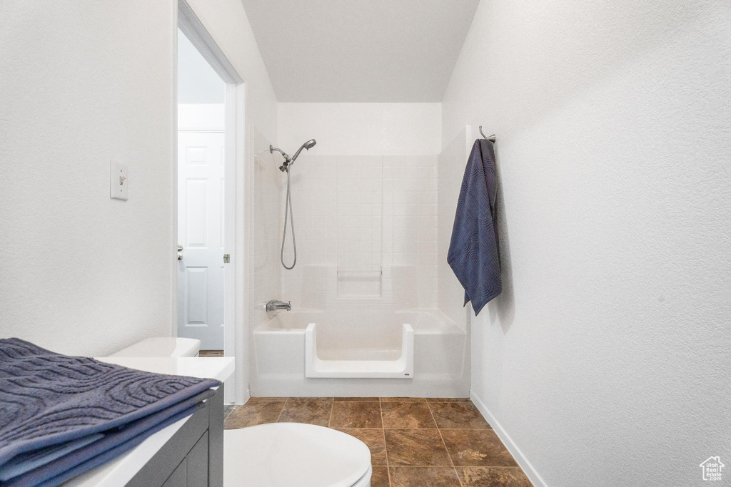 Bathroom with toilet, bathing tub / shower combination, vanity, and baseboards