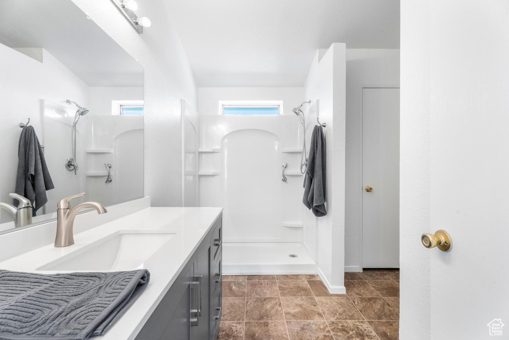 Bathroom with a shower, vanity, and baseboards