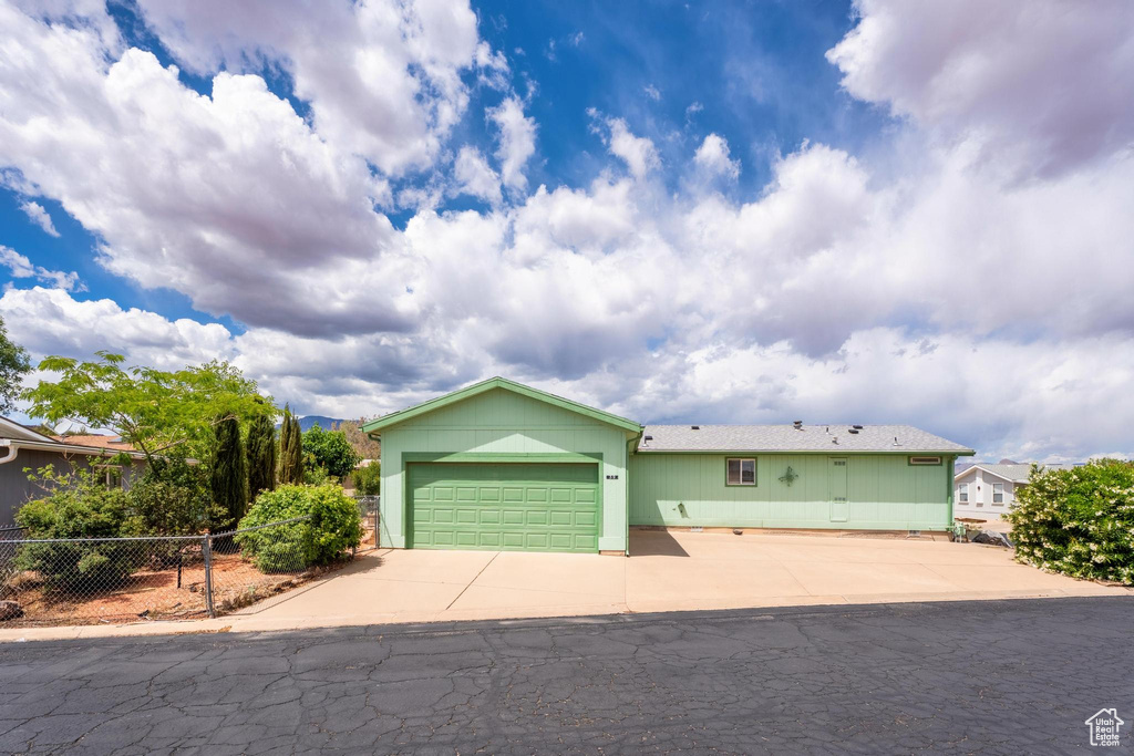 Ranch-style home with fence, an attached garage, and driveway
