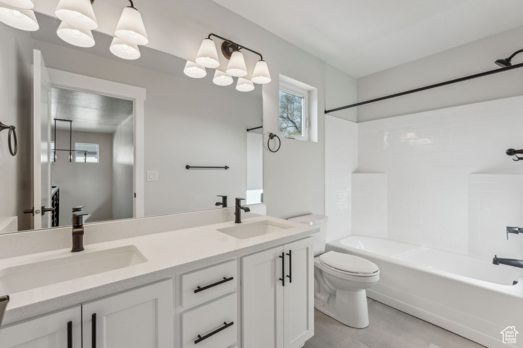Bathroom with toilet,  shower combination, and double vanity