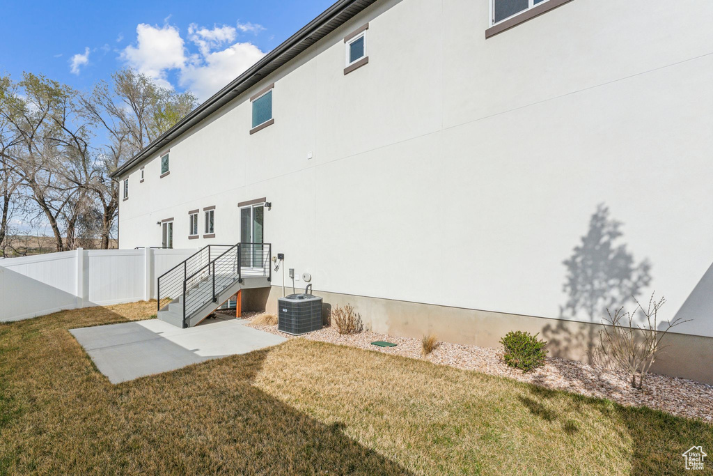 Rear view of property with a patio, stucco siding, and central AC