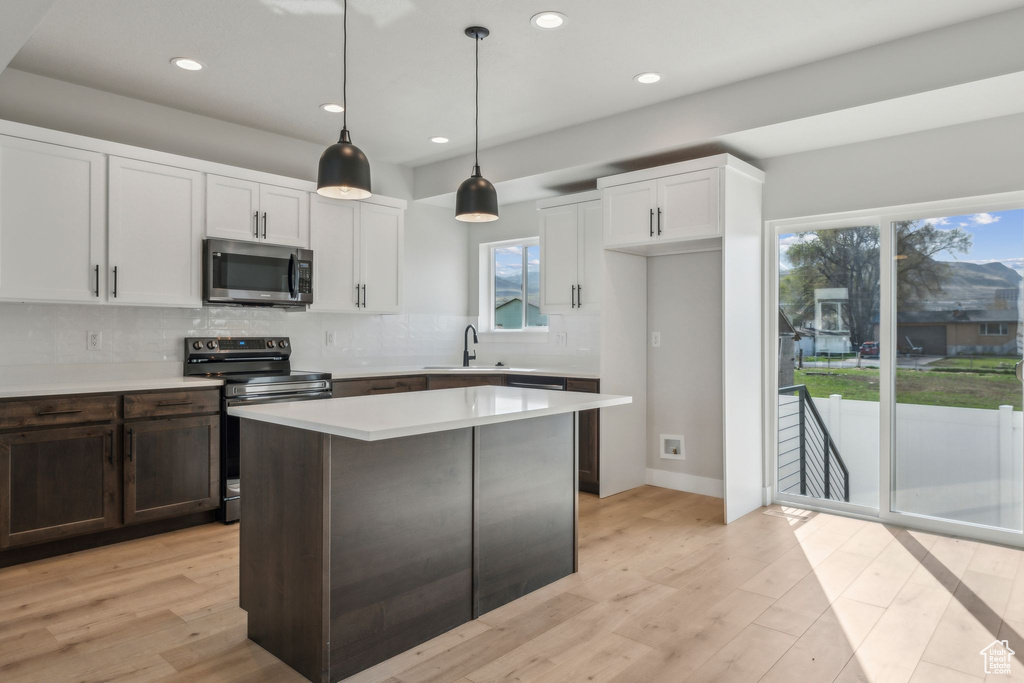 Kitchen with stainless steel appliances, a sink, recessed lighting, light countertops, and backsplash