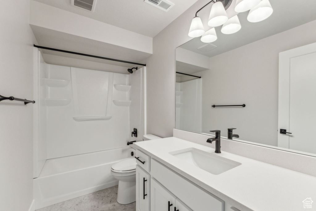 Bathroom featuring toilet, vanity, and shower / washtub combination