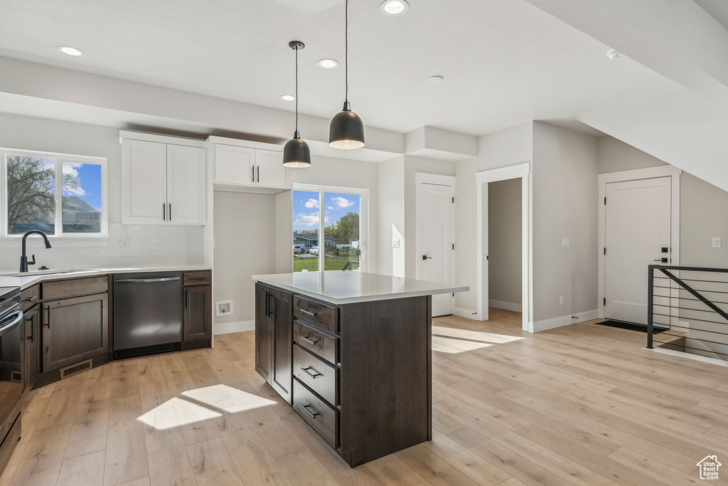 Kitchen featuring stainless steel appliances, a sink, recessed lighting, light wood-style floors, and dark brown cabinetry