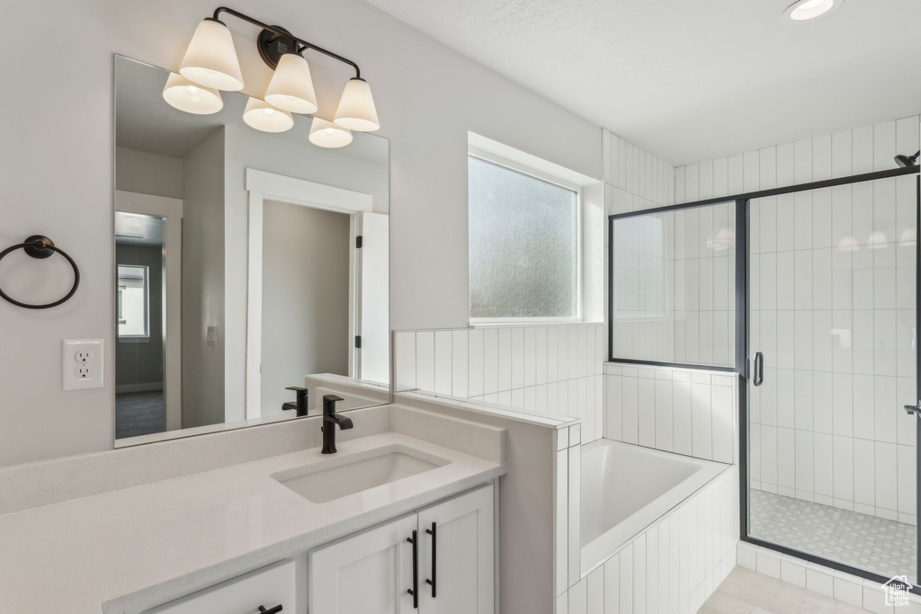 Bathroom with a shower stall, a bath, and vanity