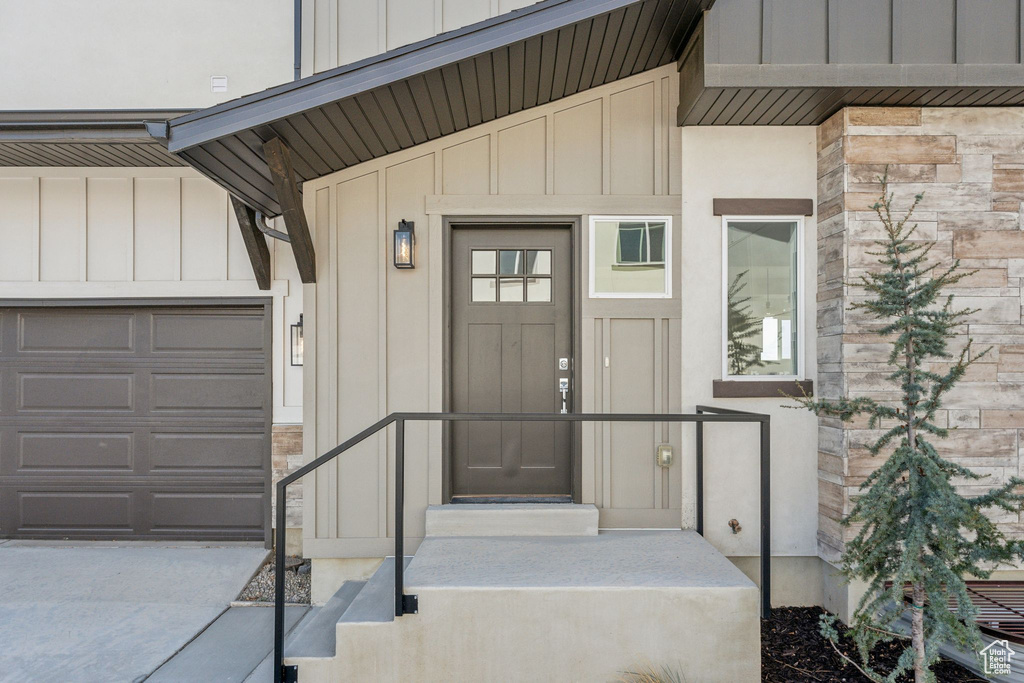 Property entrance featuring stone siding, board and batten siding, and a garage