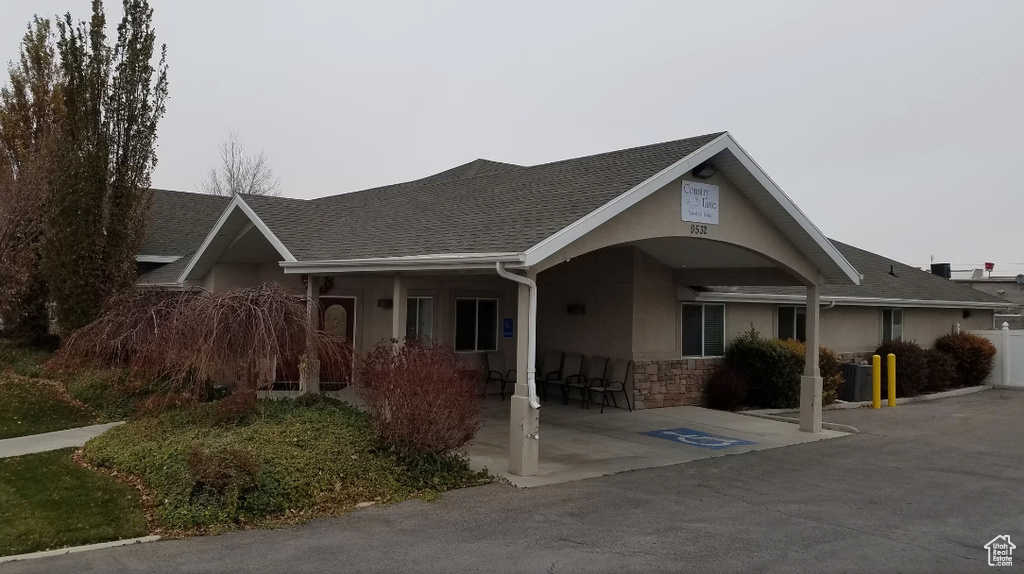 Single story home with stucco siding, stone siding, and roof with shingles