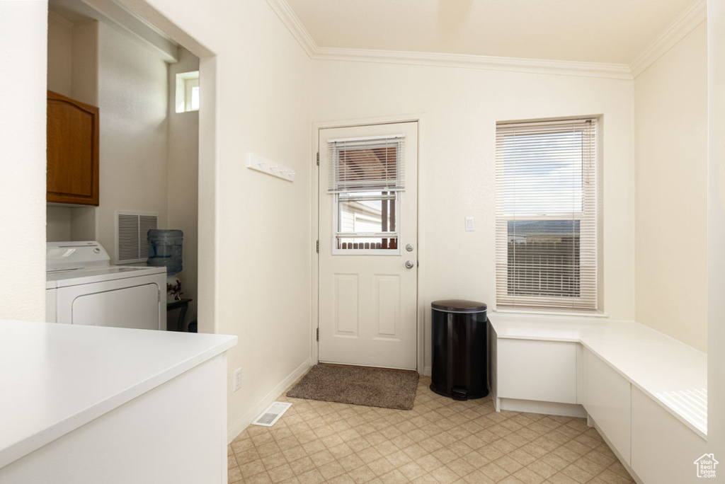 Washroom with washer / clothes dryer, crown molding, healthy amount of natural light, and light floors