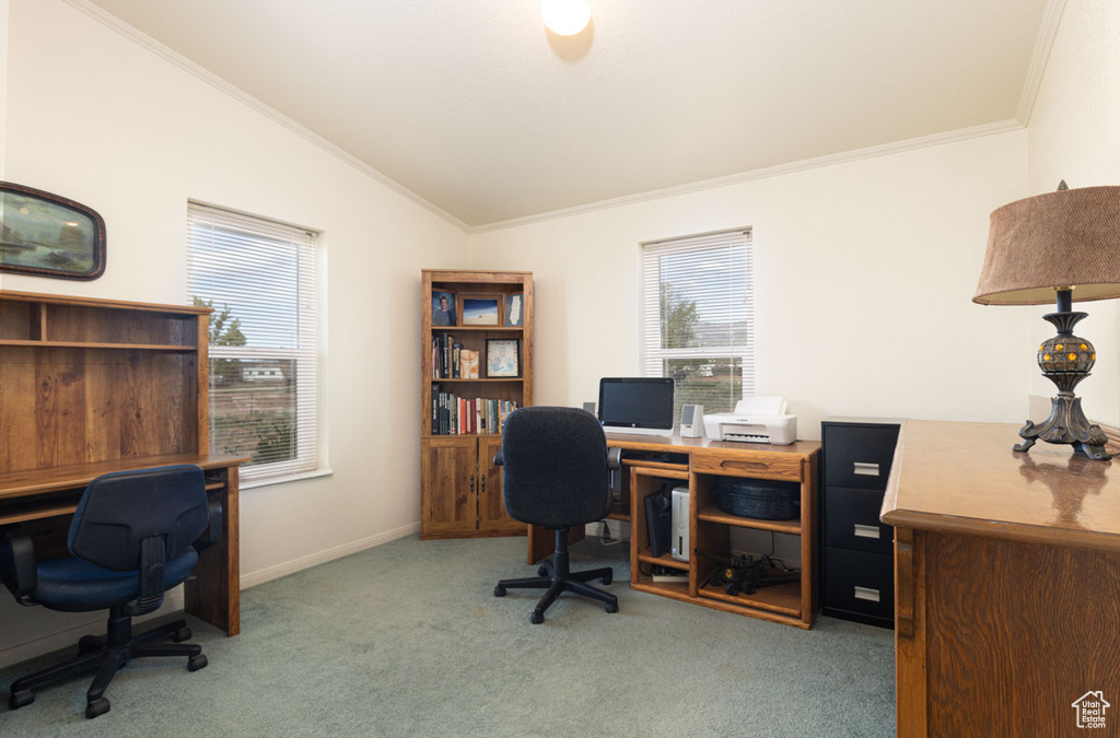 Home office featuring lofted ceiling, light colored carpet, crown molding, and baseboards