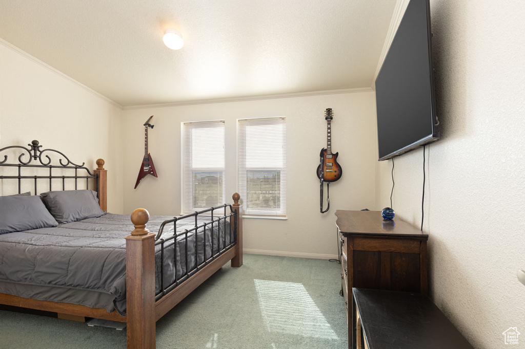 Bedroom with light carpet, crown molding, and baseboards