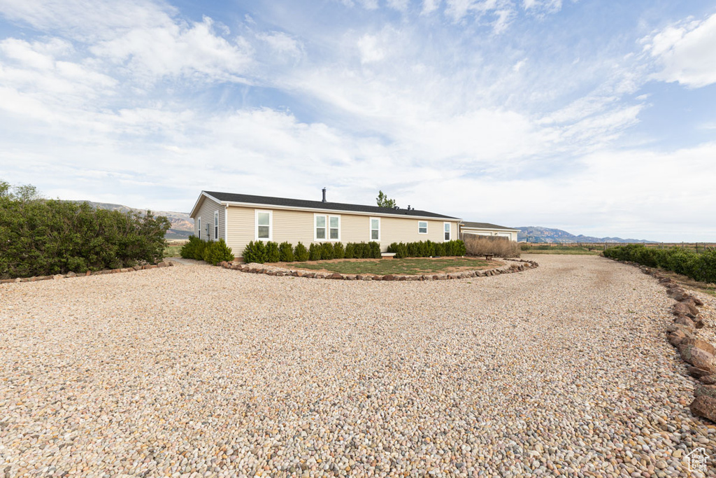View of front of property featuring gravel driveway