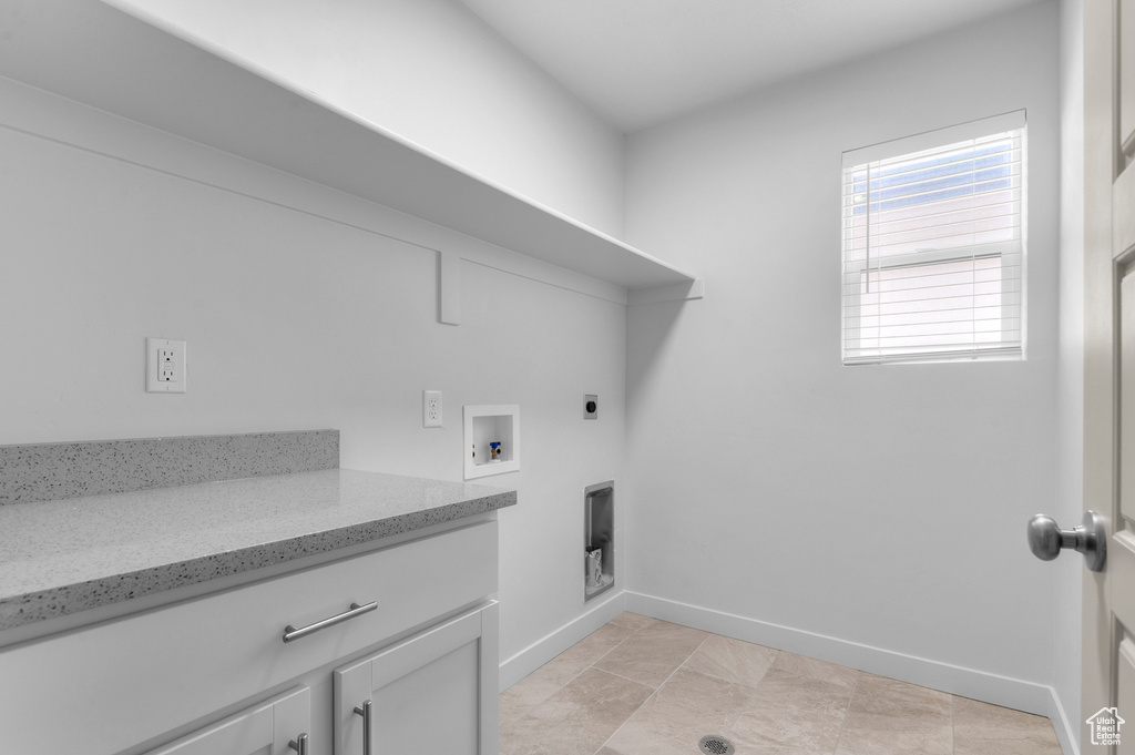 Laundry area with baseboards, hookup for an electric dryer, washer hookup, and cabinet space