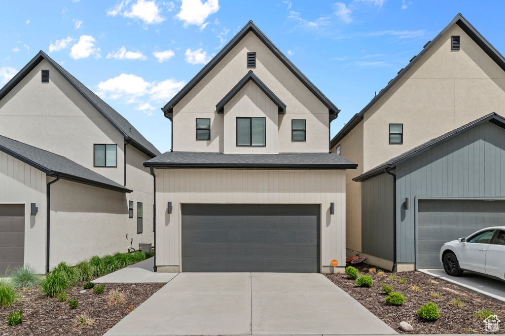 View of front of home featuring an attached garage and concrete driveway