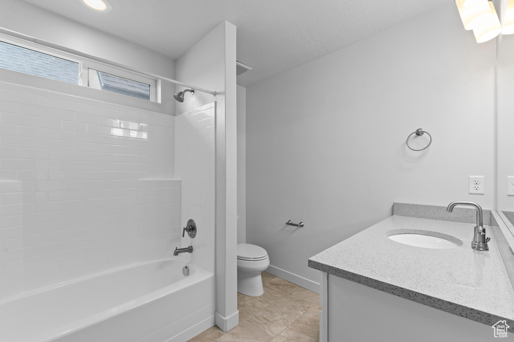 Bathroom featuring toilet, vanity, tub / shower combination, and tile patterned flooring