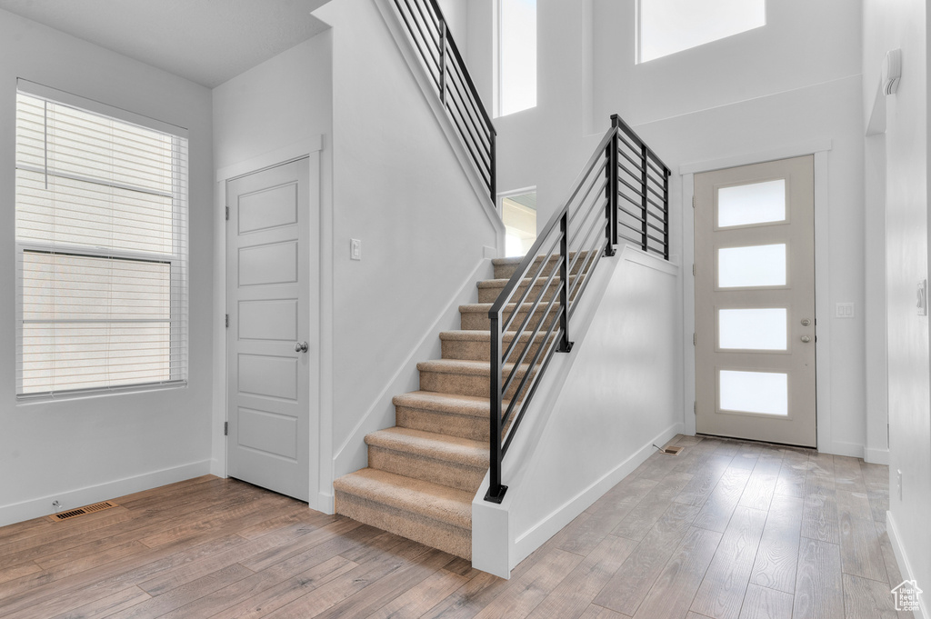 Foyer entrance featuring stairway, plenty of natural light, and light wood finished floors