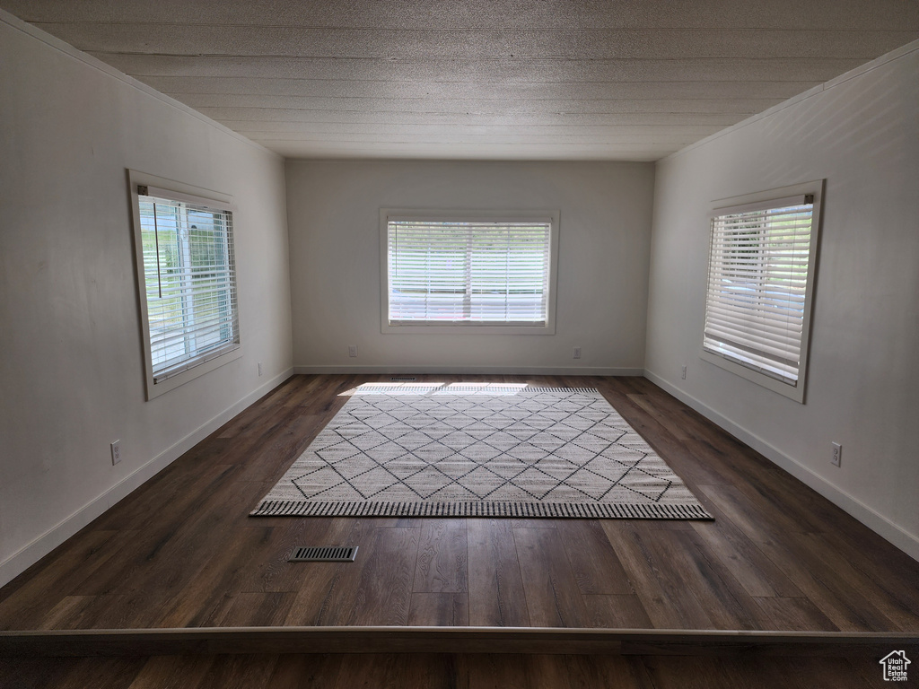 Spare room with healthy amount of natural light, wood finished floors, and baseboards