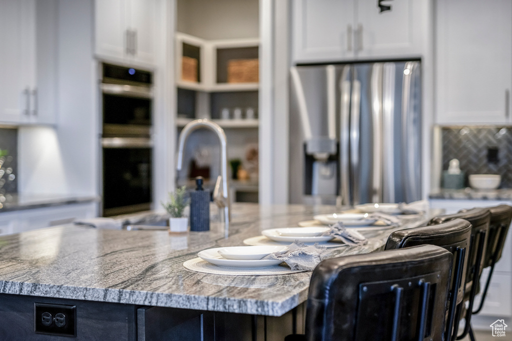 Kitchen featuring appliances with stainless steel finishes, white cabinetry, and a kitchen island