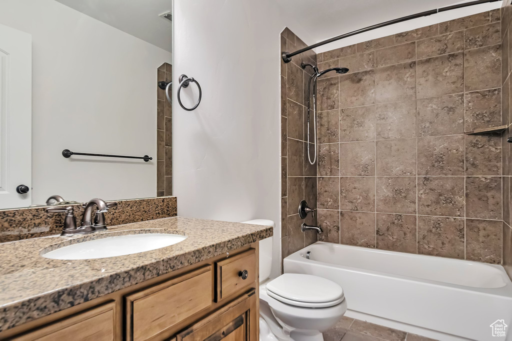 Bathroom featuring toilet, shower / bath combination, and vanity