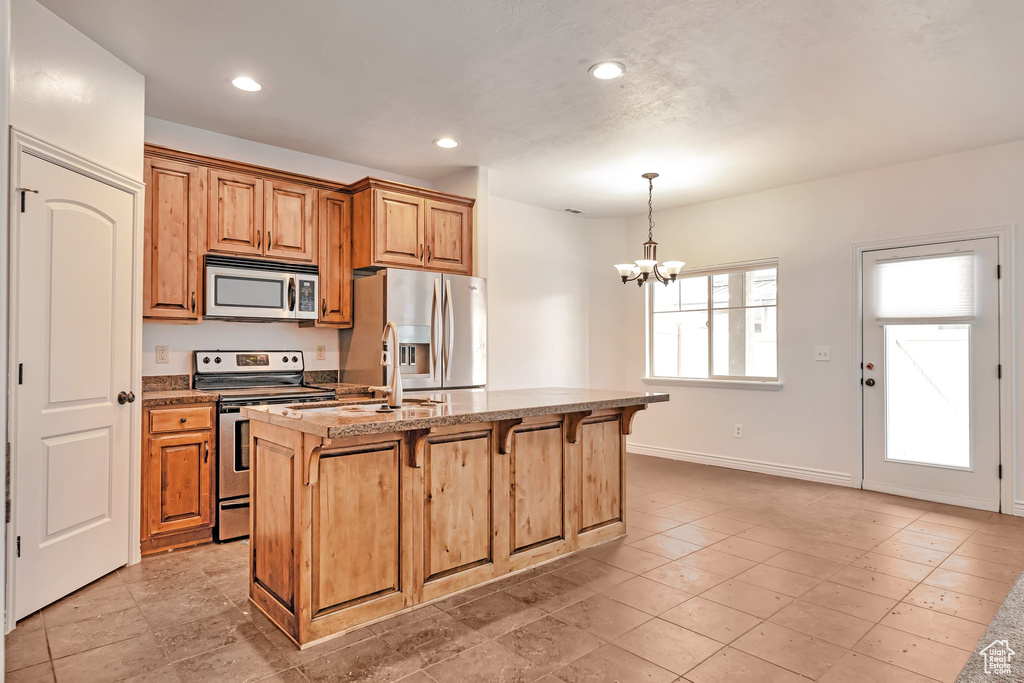 Kitchen featuring appliances with stainless steel finishes, a chandelier, a breakfast bar area, recessed lighting, and baseboards