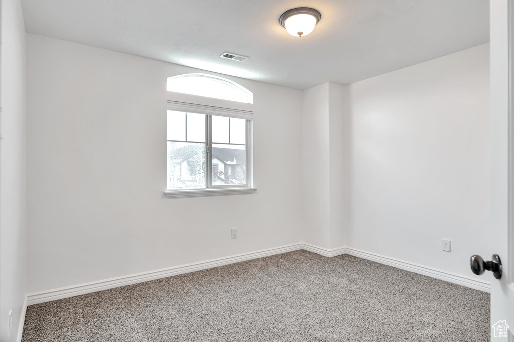 Empty room featuring carpet flooring and baseboards