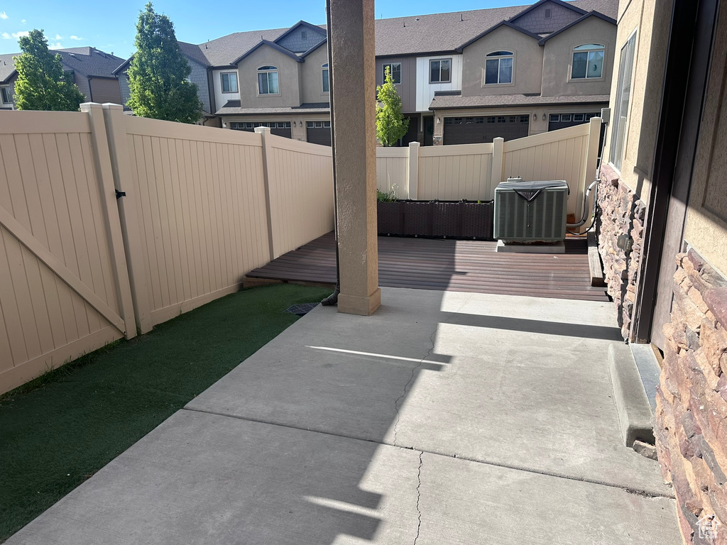 View of patio with central AC unit, a residential view, and fence