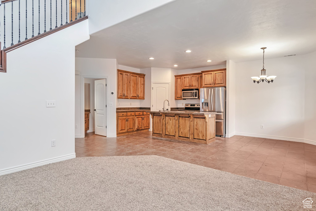 Kitchen featuring stainless steel appliances, a chandelier, recessed lighting, baseboards, and open floor plan